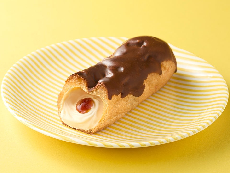 黄色いお皿にのった、カラメル風味チョコをかけたエクレアの断面