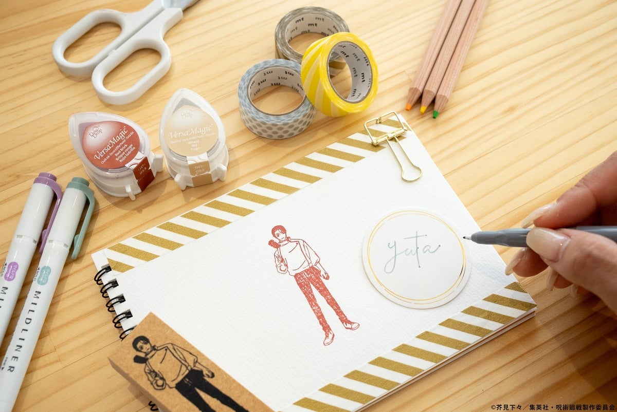 リングノートに乙骨憂太のスタンプを赤系のインクで押し、横に「yuta」と手書きしている様子