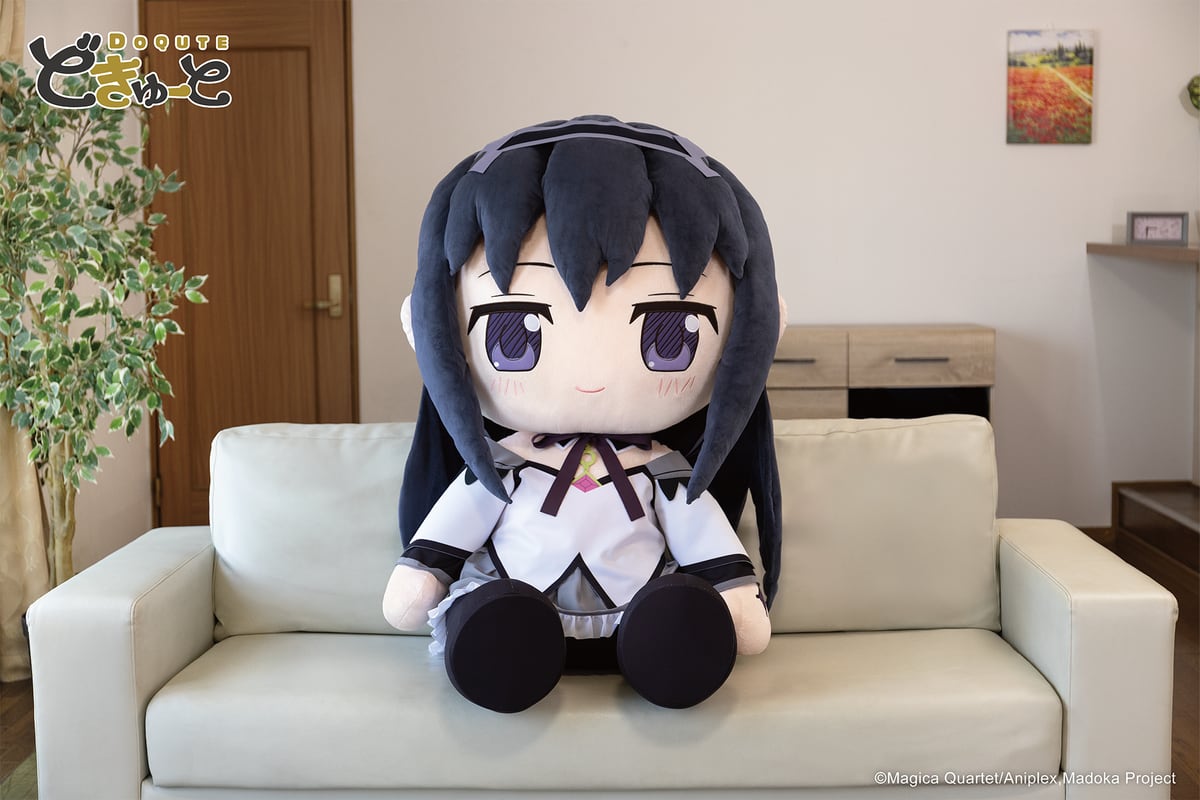 ソファに座った約100cmの「超特大ぬいぐるみ 暁美ほむら」。黒い長髪にカチューシャ、白と灰色の衣装、黒い靴
