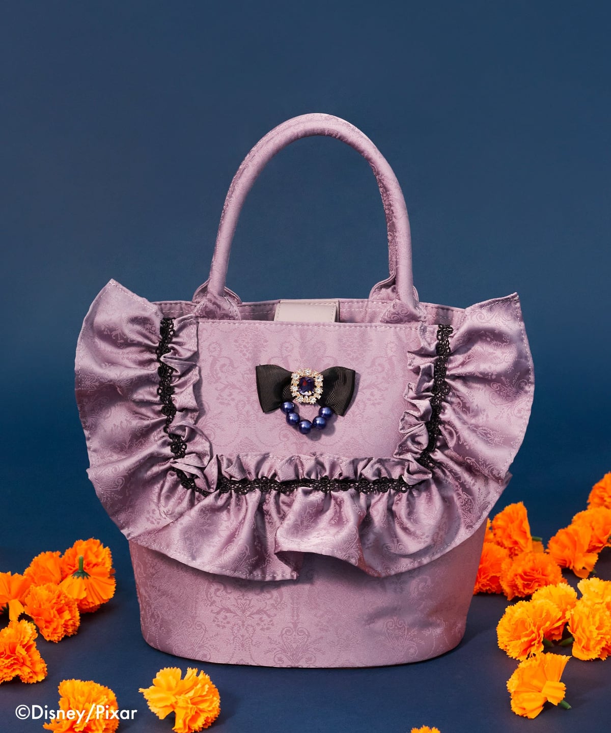 Maison de FLEUR『リメンバー・ミー』イメルダ/ドレスバッグ。ラベンダー色のジャカード生地にフリルとリボンの付いたバケットバッグ