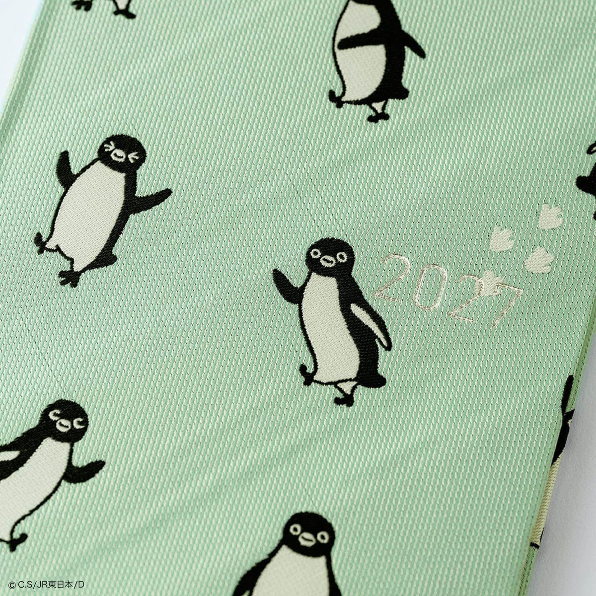 weeks「とことこ」。ミントグリーンの生地に歩いたり手を広げたりするSuicaのペンギンが織り込まれ、「2027」の文字入り